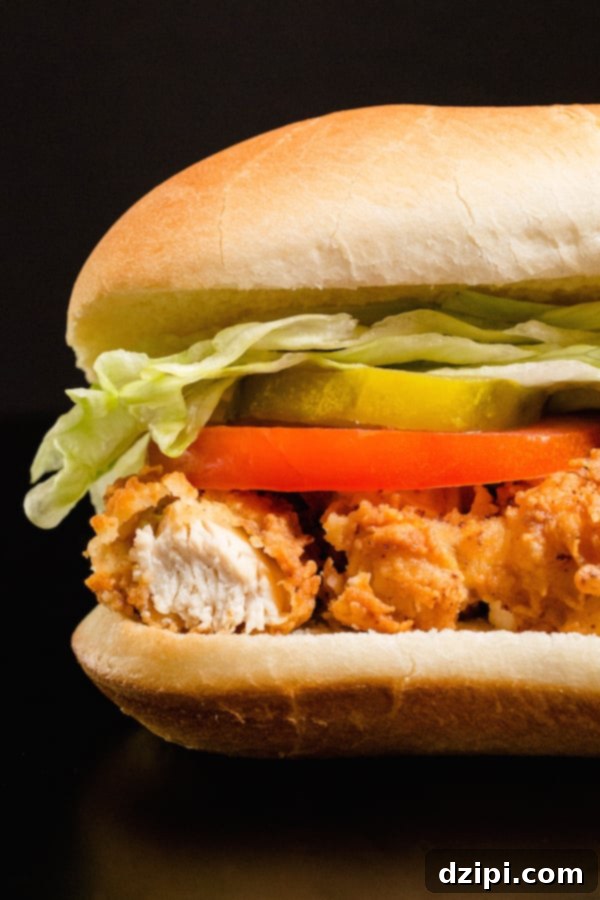 The Ultimate Homemade Chicken Tender Sub 2 Homemade Chicken Tender Sub Sandwich on a black background, perfectly toasted and filled with delicious ingredients.