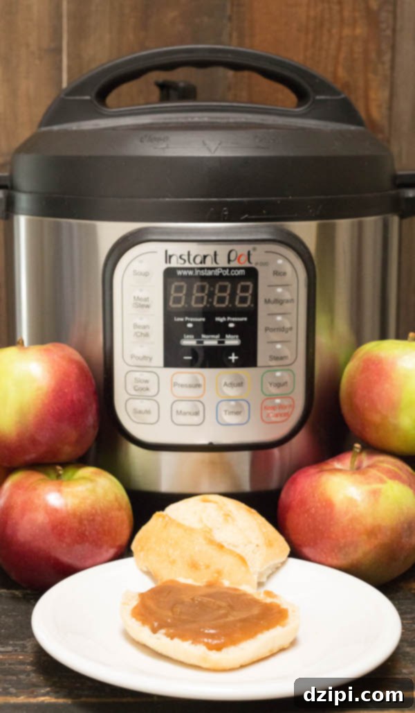 Velvety Instant Pot Apple Butter 6 A fresh baked roll topped generously with Instant Pot Apple Butter, placed invitingly in front of the Instant Pot appliance.