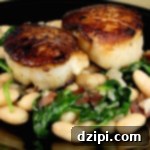 Close-up of seared scallops with white beans and spinach, ready to serve.