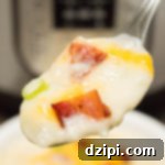 Instant Pot Ultimate Loaded Potato Soup 4 A bowl of potato soup topped with cheese, bacon, and green onions.