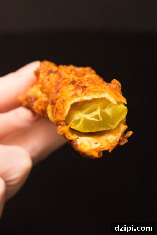 The inside of a Nashville Hot Pickle after it has been bitten, revealing the juicy pickle beneath the crispy breading.