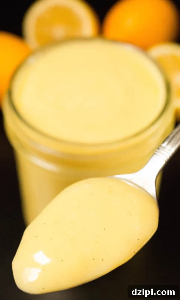 A spoonful of homemade Meyer Lemon Curd, showcasing its creamy texture and vibrant yellow color.