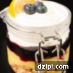 A close-up of a Meyer Lemon & Blueberry Parfait, garnished with a lemon slice and fresh blueberries, ready to be served.