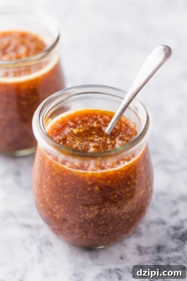 Clone Your Favorite Restaurant Meals At Home 16 Medium shot of brown Benihana Ginger sauce in a small jar with a metal spoon