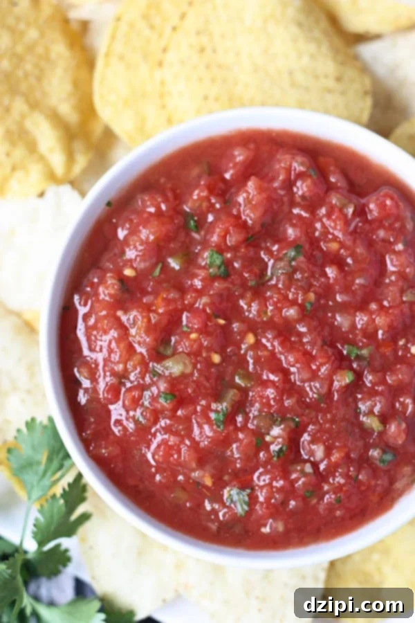 Clone Your Favorite Restaurant Meals At Home 19 Closeup of Chilis copycat salsa in a white bowl with tortilla chips in the background