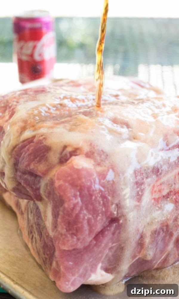 Cherry Cola Smoked Pulled Pork 6 Cherry Coke being poured over a raw pork shoulder on a baking sheet, preparing it for the spice rub.