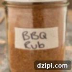 BBQ spice rub in a glass mason jar on a wood background, ready to be used