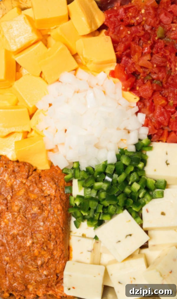 Close-up of smoked queso ingredients: Velveeta, pepper jack, chorizo, Rotel, chopped white onion, and chopped jalapeños, showcasing the freshness and variety.
