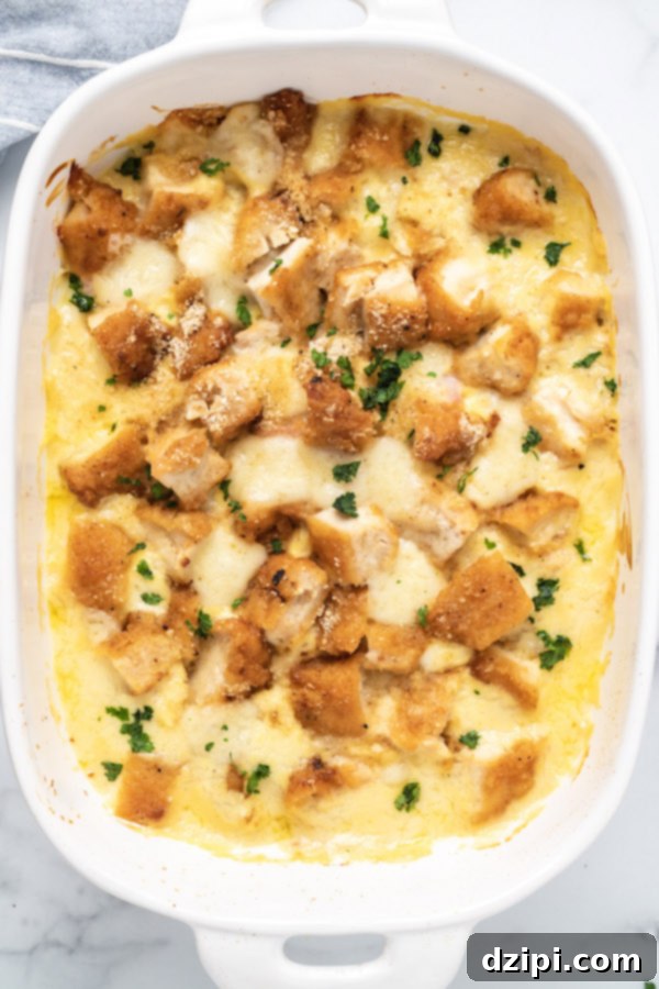 Overhead shot of a white 9x13 dish filled with baked Chicken Cordon Bleu Casserole, showcasing its golden-brown topping and creamy interior.