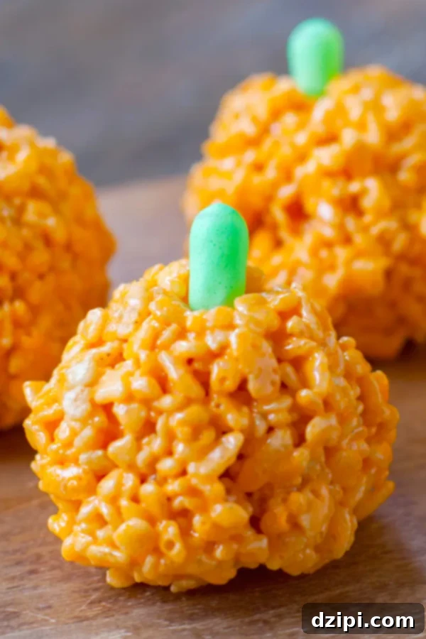 An orange Rice Krispie treat expertly shaped like a small pumpkin, complete with a green candy on top for the stem