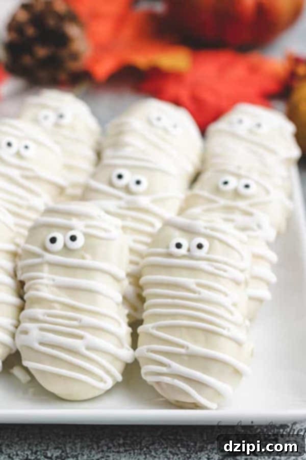 Delightful Nutter Butter cookies transformed into adorable mummies for Halloween with white chocolate and candy eyes