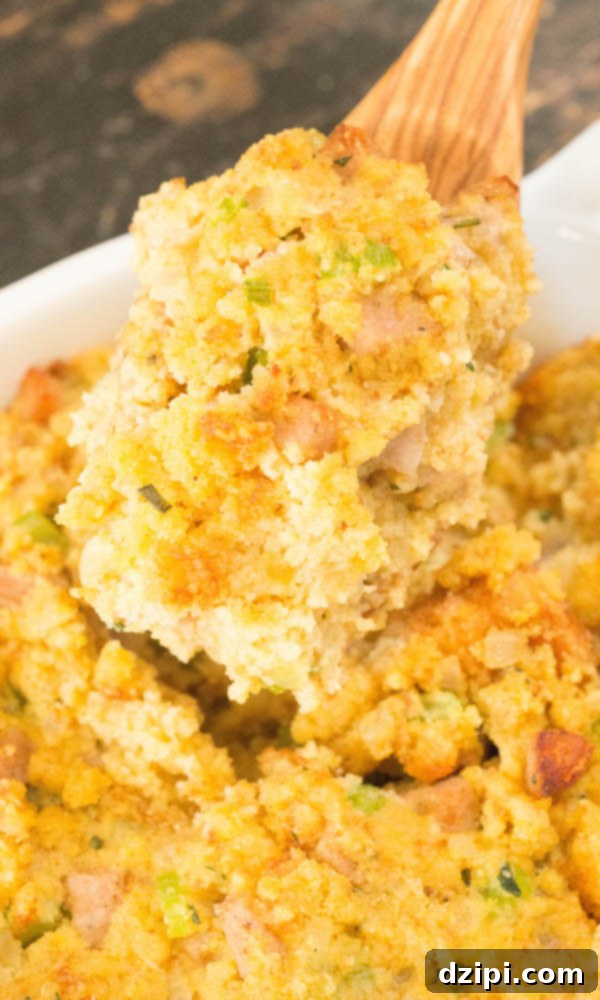 A wooden serving spoon full of cornbread stuffing
