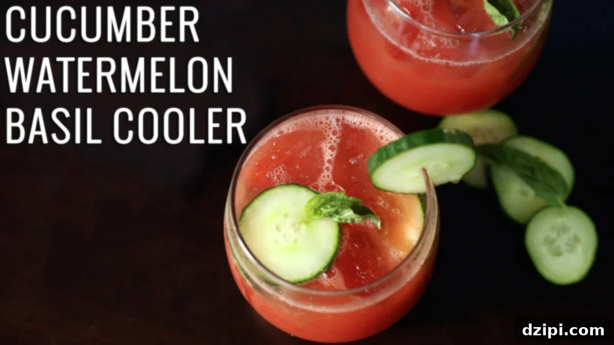 Vibrant Cucumber Watermelon Basil Refresher 2 Vibrant pink-red Cucumber Watermelon Basil Cooler in a stemless wine glass, garnished with cucumber slices and fresh basil leaves.
