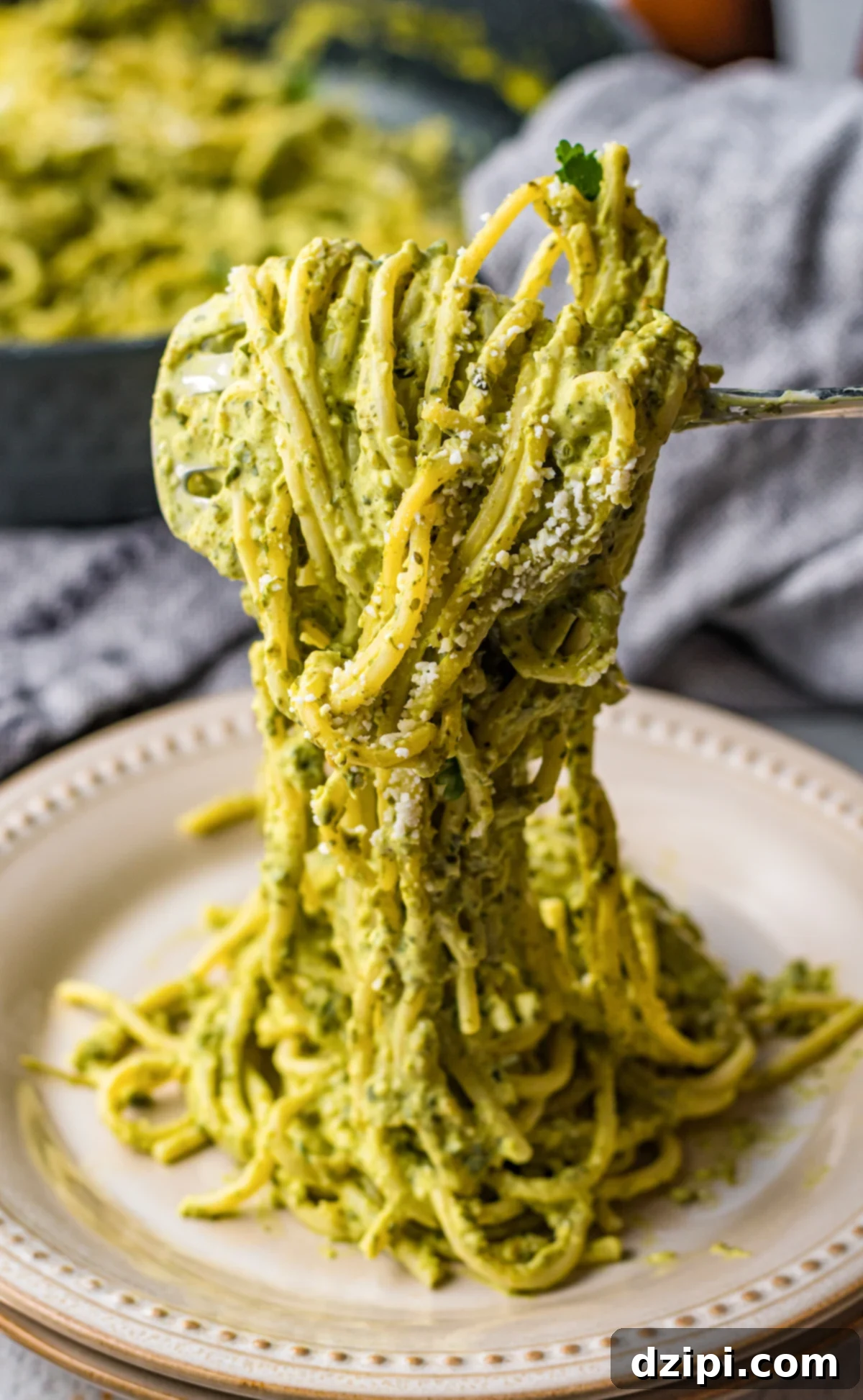 A fork gracefully twirls vibrant green Mexican spaghetti over a pristine white plate, showcasing the creamy poblano sauce and inviting texture.