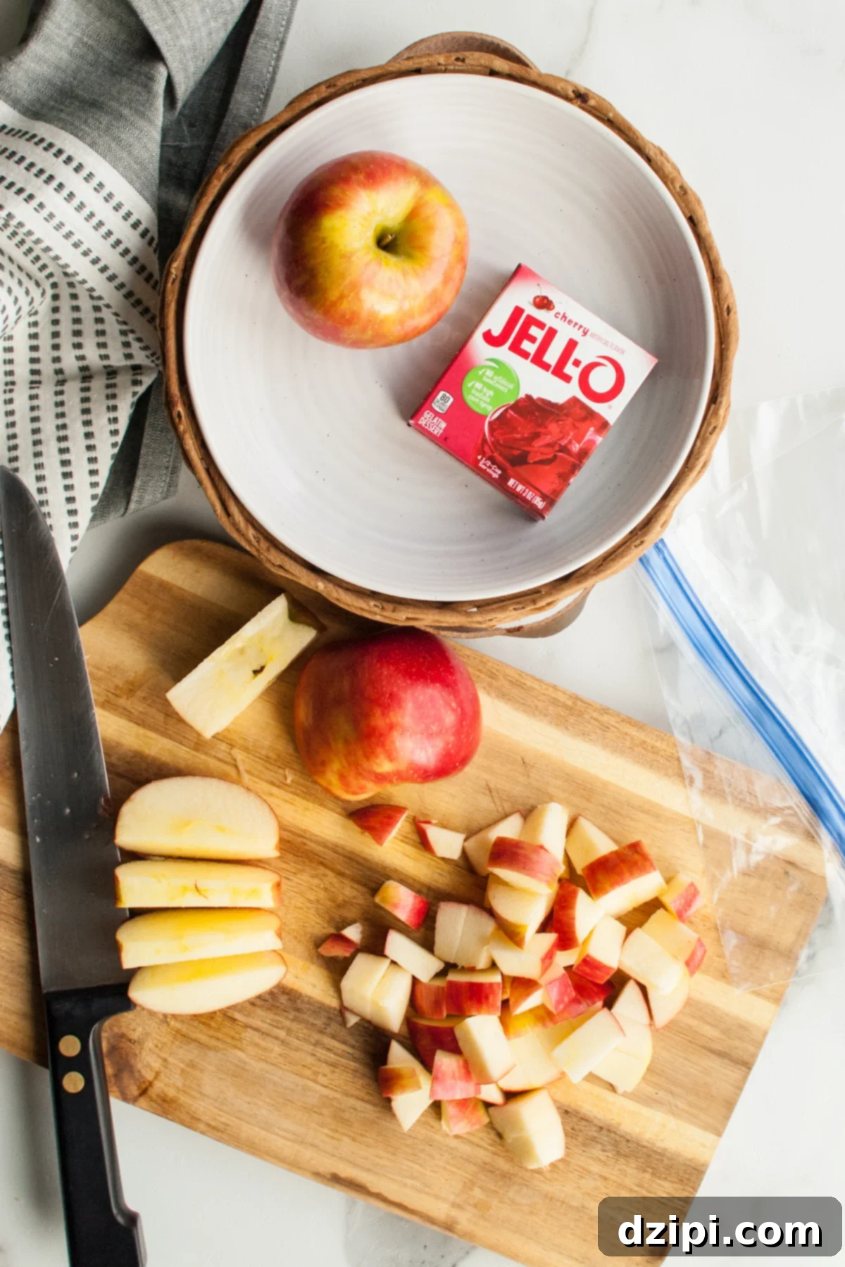 Overhead view of chopped apples on a cutting board next to a box of Jello