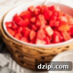 A large serving filled with chopped apples covered in red cherry Jello powder