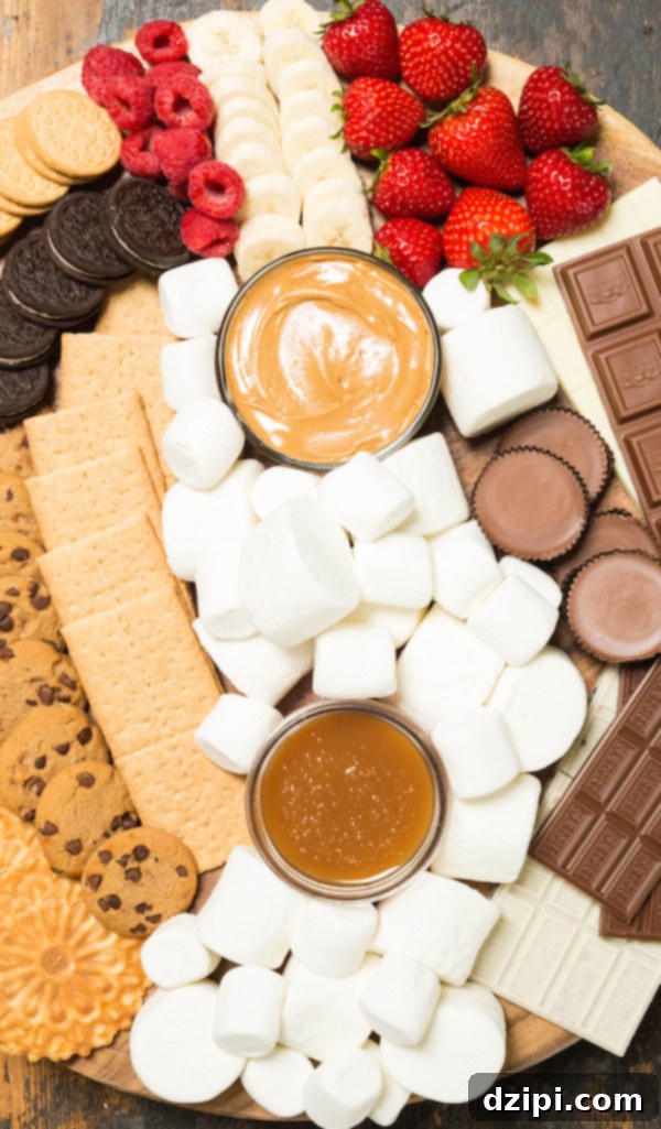 A beautifully arranged s'mores board overflowing with a variety of ingredients, including chocolate chip cookies, Oreos, graham crackers, fresh fruit, different chocolates, and peanut butter, inviting guests to create their own s'mores.
