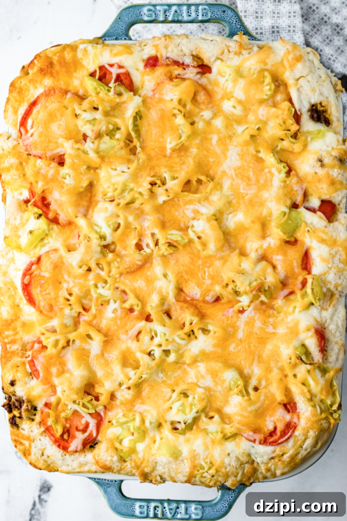 Overhead view of a baked John Wayne Casserole in a blue 'Staub' casserole dish.