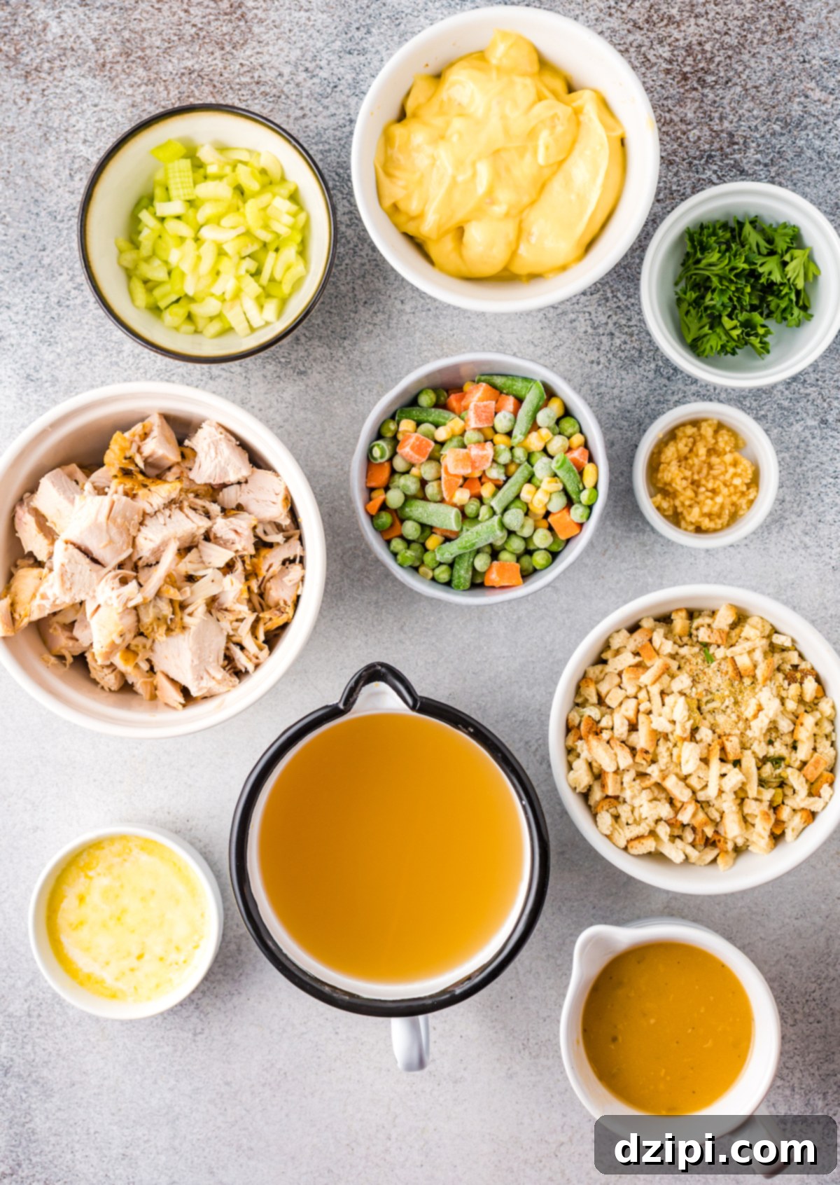 An overhead shot displaying all the carefully prepped ingredients for the Turkey Stuffing Casserole, neatly arranged in small prep bowls on a countertop, ready to be combined.