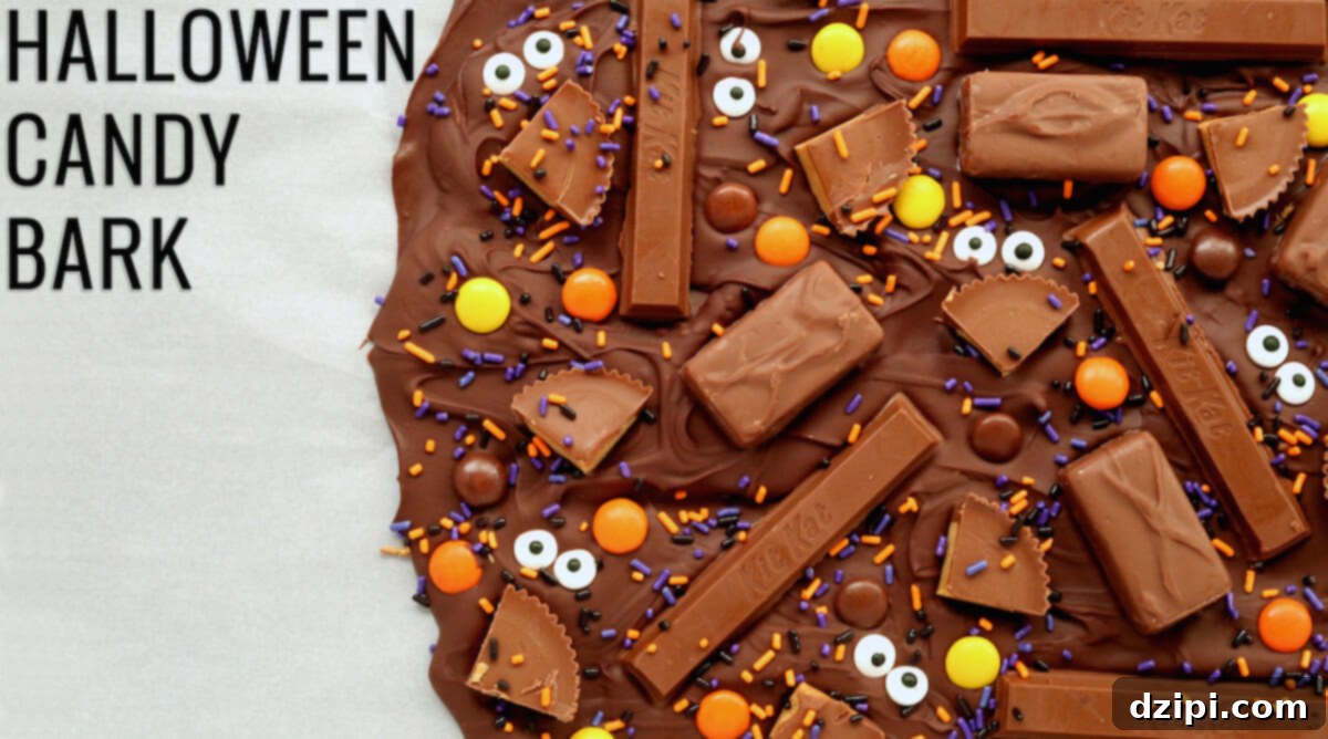 A close up of melted chocolate with mini Halloween candies and edible eyes on parchment paper. The final product is Halloween Candy Bark, a festive and fun dessert.