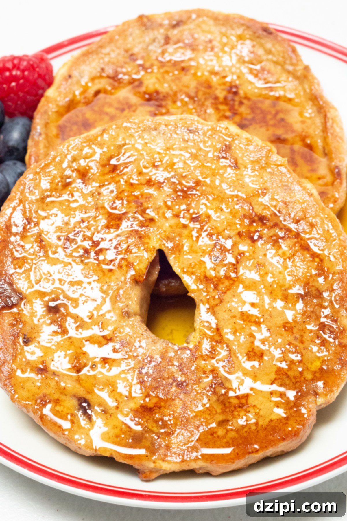Maple Glazed French Toast Bagel 6 Two pieces of bagel that have been cooked like french toast sit on a plate.