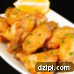 Glazed honey lemon pepper wings on a black background.