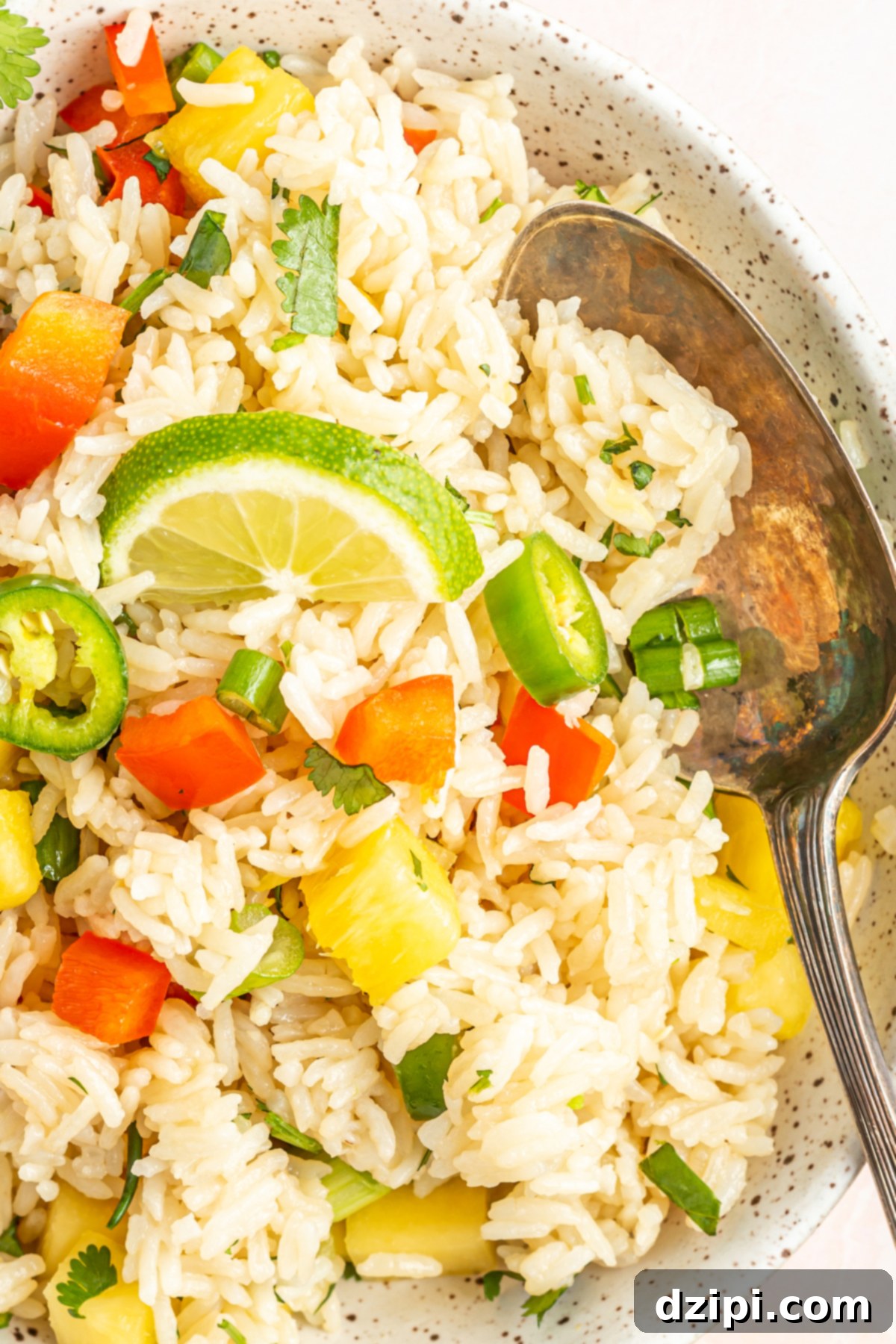 A large serving bowl filled with pristine white Instant Pot coconut rice, beautifully mixed with colorful pineapple chunks and red bell peppers.