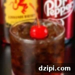 A rocks glass with fireball and dr. pepper sits in front of a bottle of each.