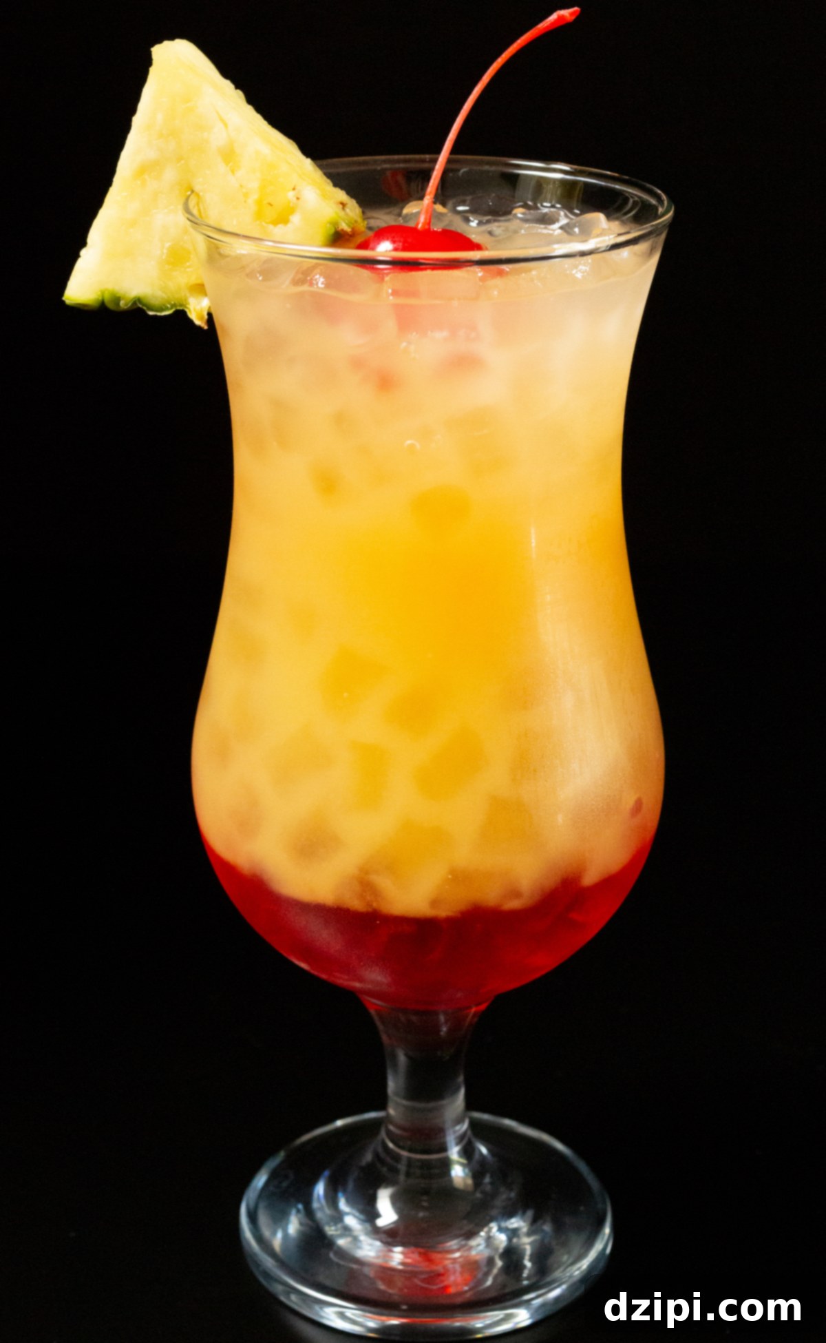 A hurricane glass filled with a vibrant Bahama Mama cocktail, set against a dark background, showcasing its tropical allure.