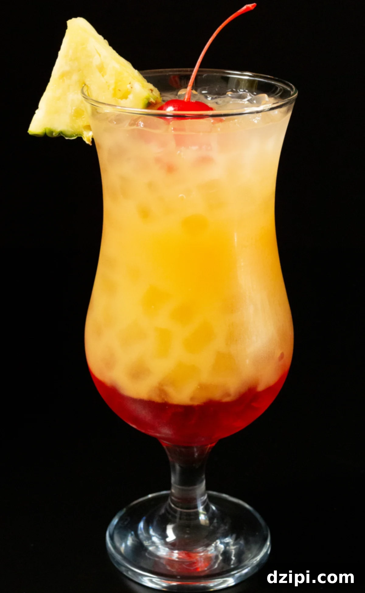 A vibrant Bahama Momma cocktail in a hurricane glass, garnished with a pineapple slice and cherry, set against a dark background.