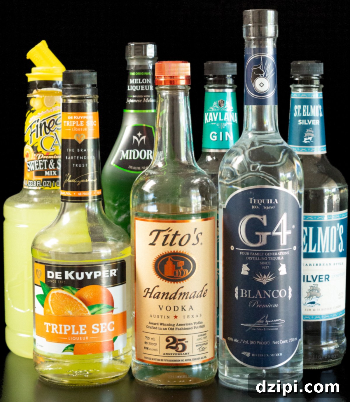 The bottles of alcohol and mixers for Tokyo Iced Tea are lined up on a black background.