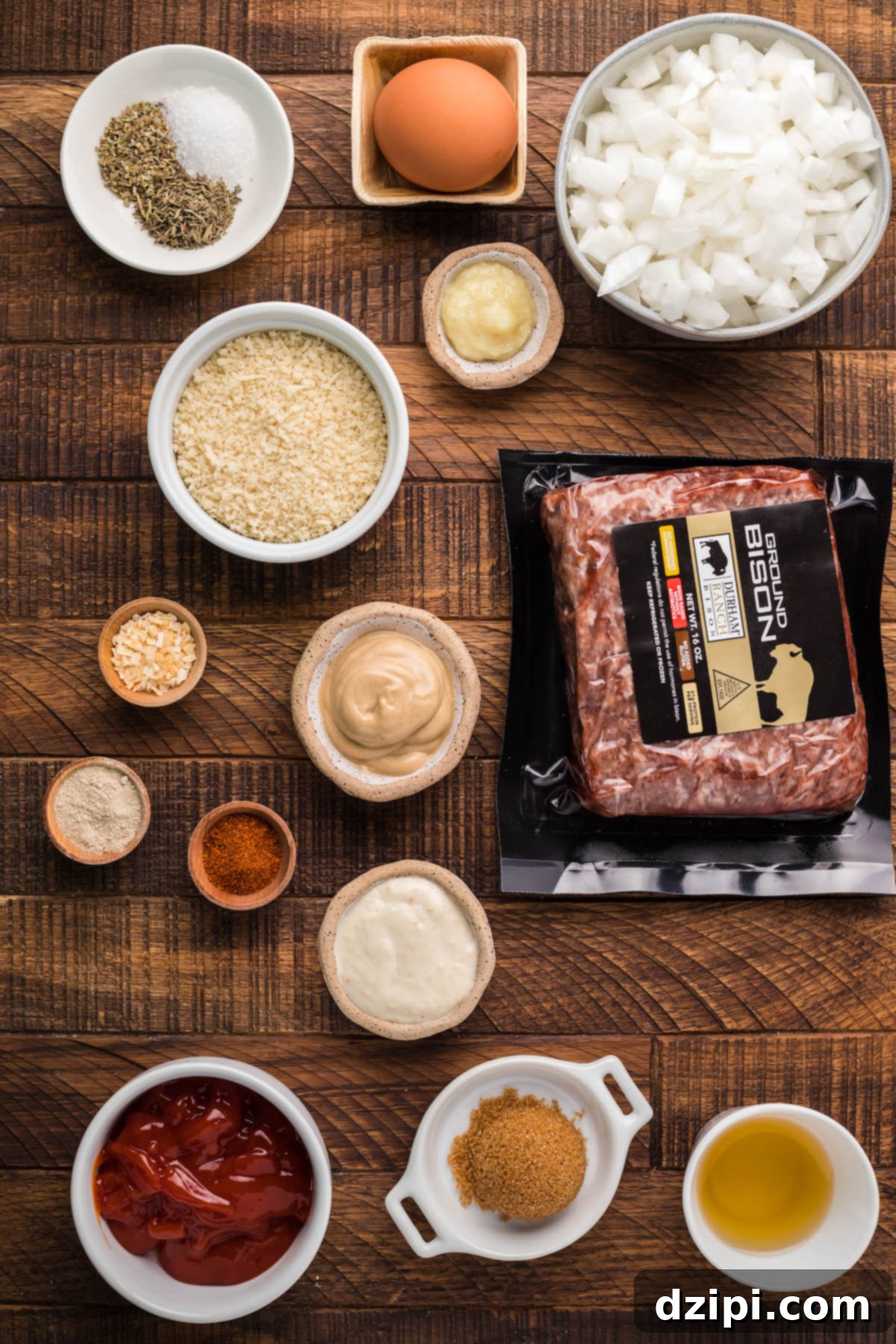 Hearty Bison Meatballs 4 All the ingredients to make Bison meatballs in small prep bowls on a brown wood background.