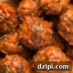 Hearty Bison Meatballs 7 Close up of several Bison Meatballs lightly covered in BBQ sauce.