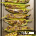 Charred Hatch Chiles 7 Overhead view of a baking sheet filled with green roasted Hatch Chiles.