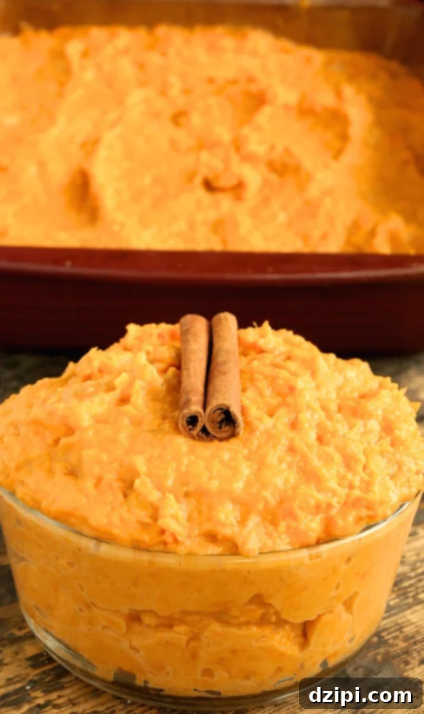 A glass serving bowl of Thanksgiving sweet potatoes sits in front of a baking dish.
