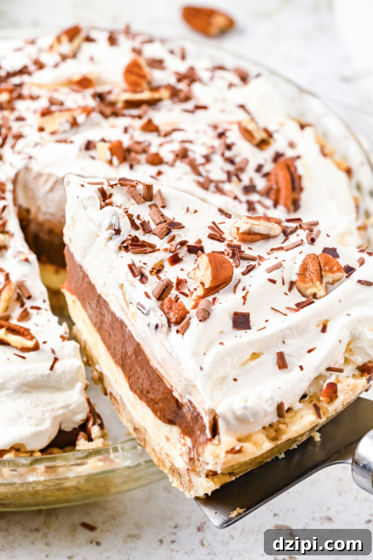 A slice of possum pie been lifted out of a glass pie plate via a pie cutter.