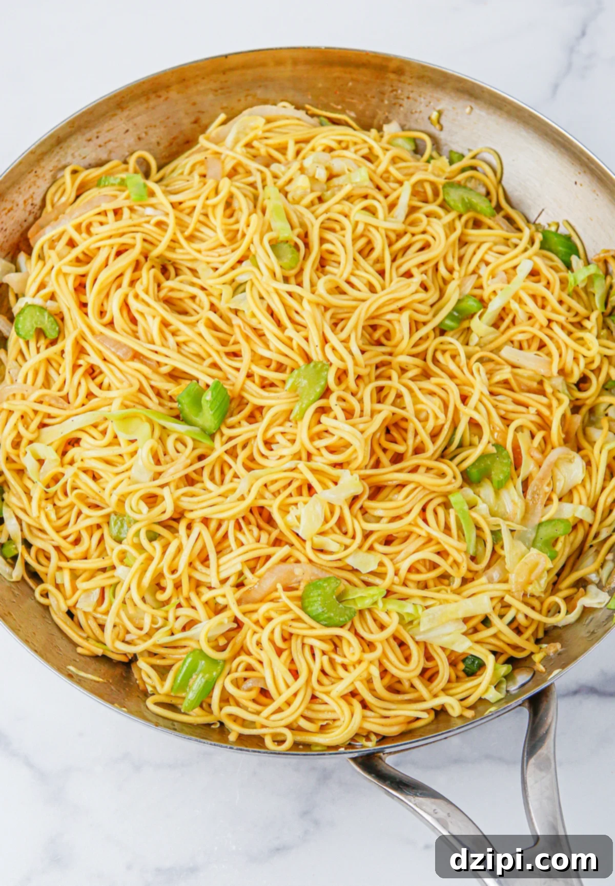 Iconic Panda Express Chow Mein 6 A large sautee pan brimming with expertly cooked chow mein noodles, garnished with vibrant sliced green onion, ready to be served.