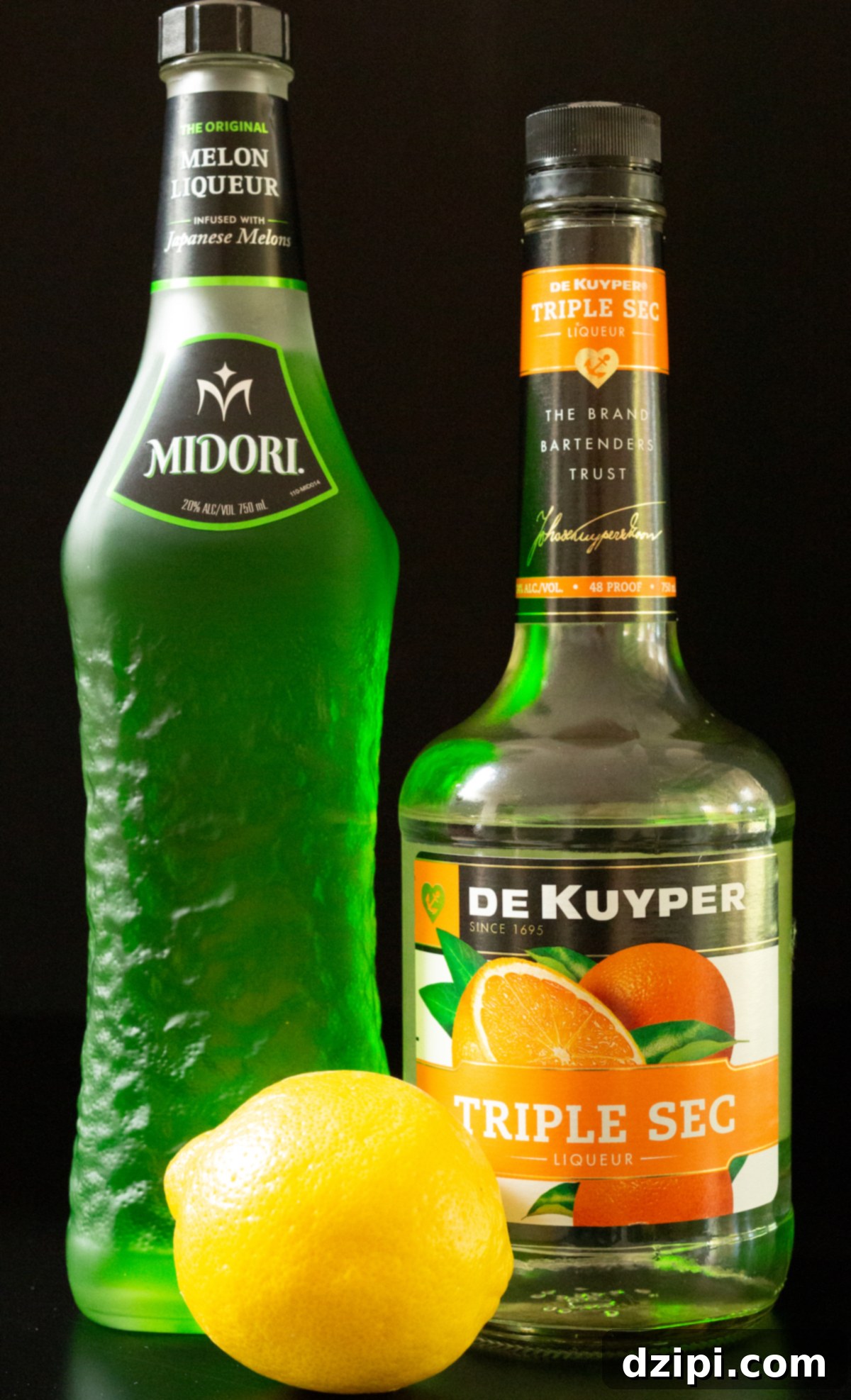 A bottle of Midori, triple sec, and lemon juice on a black background.