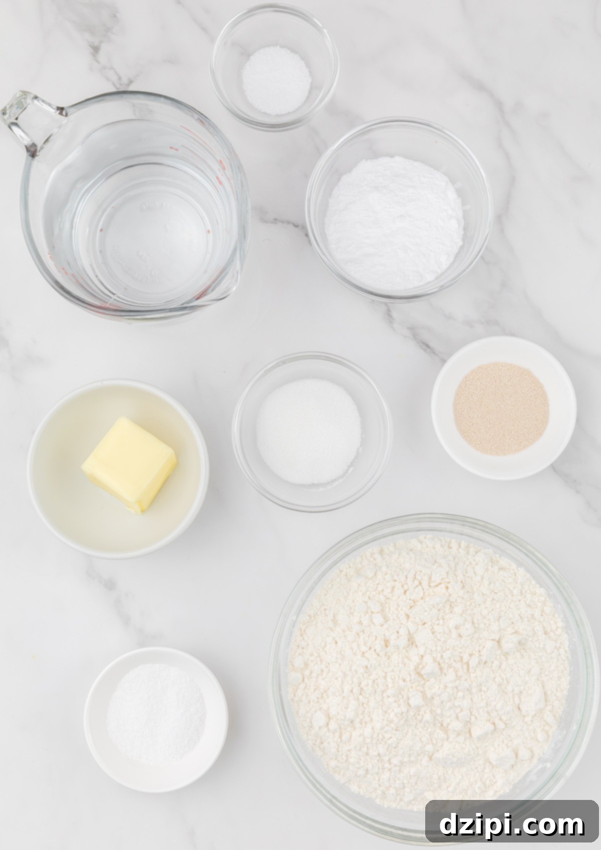 An overhead view displaying all the core ingredients required to make air fryer pretzel bites, meticulously arranged in small prep bowls on a pristine white background.