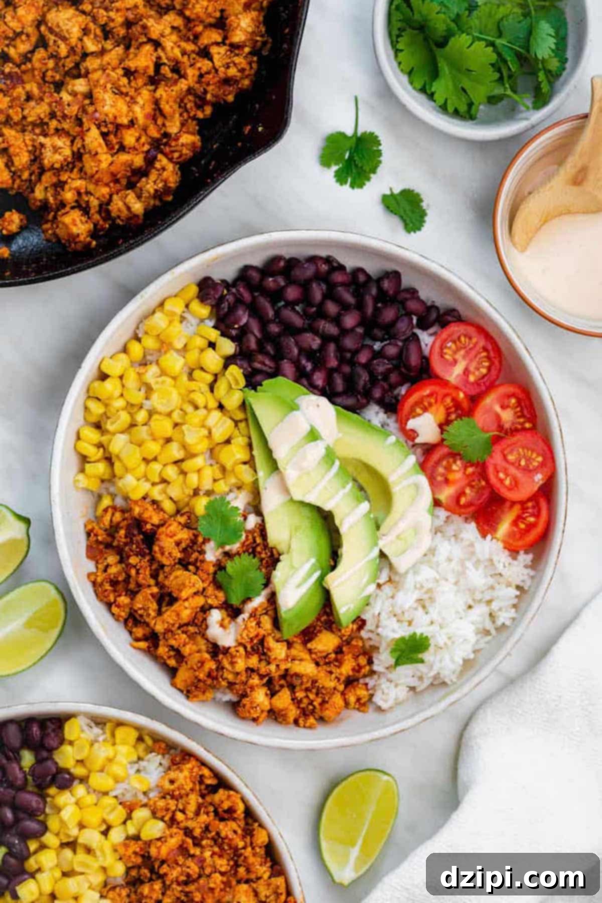A colorful bowl filled with fluffy rice, hearty copycat Chipotle sofritas, fresh corn, black beans, bright cherry tomatoes, creamy avocado, and aromatic cilantro.