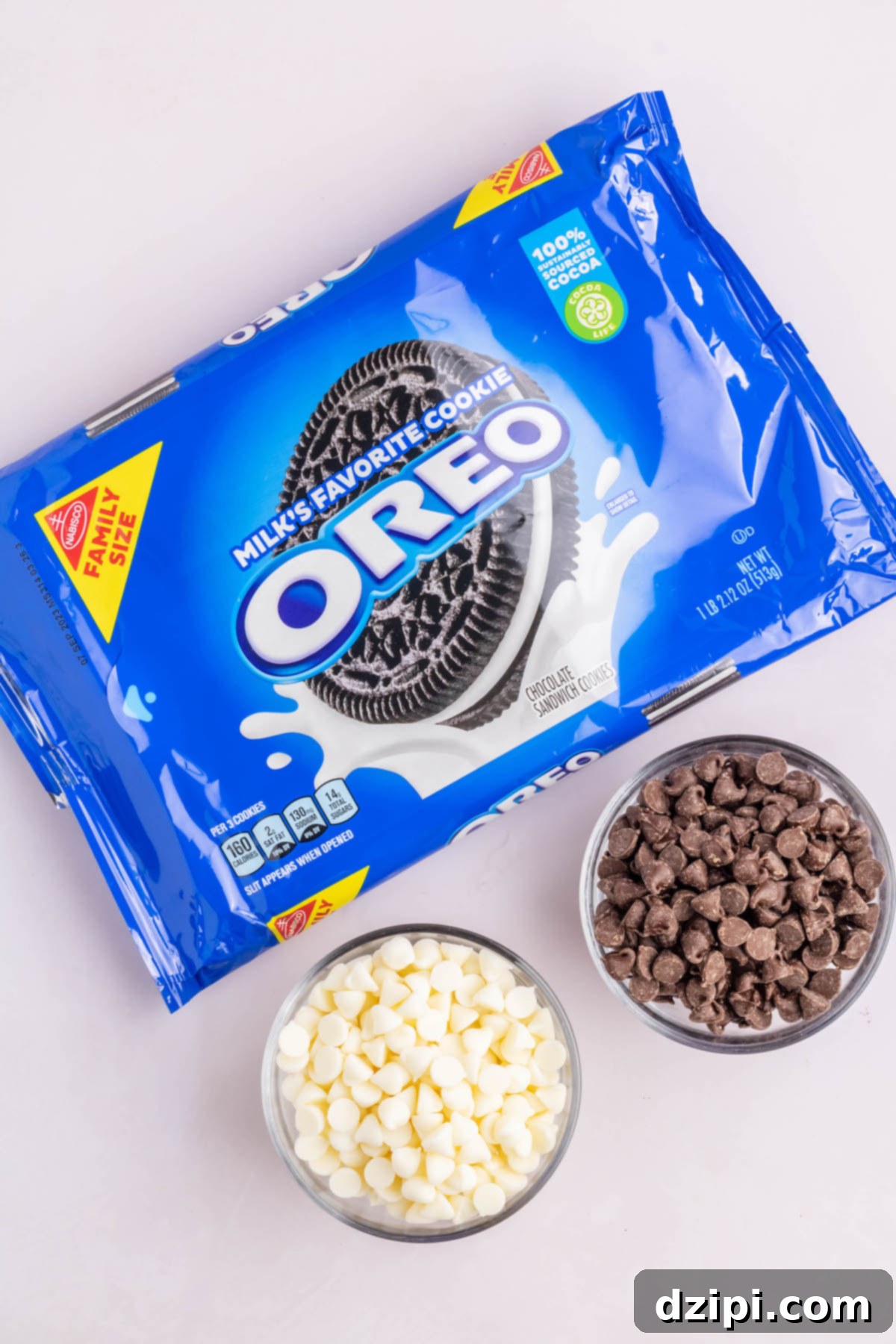A package of Oreo cookies next to prep bowls of milk chocolate chips and white chocolate chips.