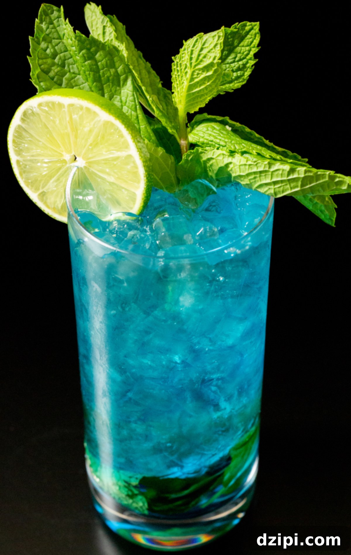 Sapphire Sip 6 A tall glass brimming with pebble ice and a stunning ocean-blue mojito, artfully garnished with a lime wheel and a fresh mint sprig, ready to be enjoyed on a summer day.