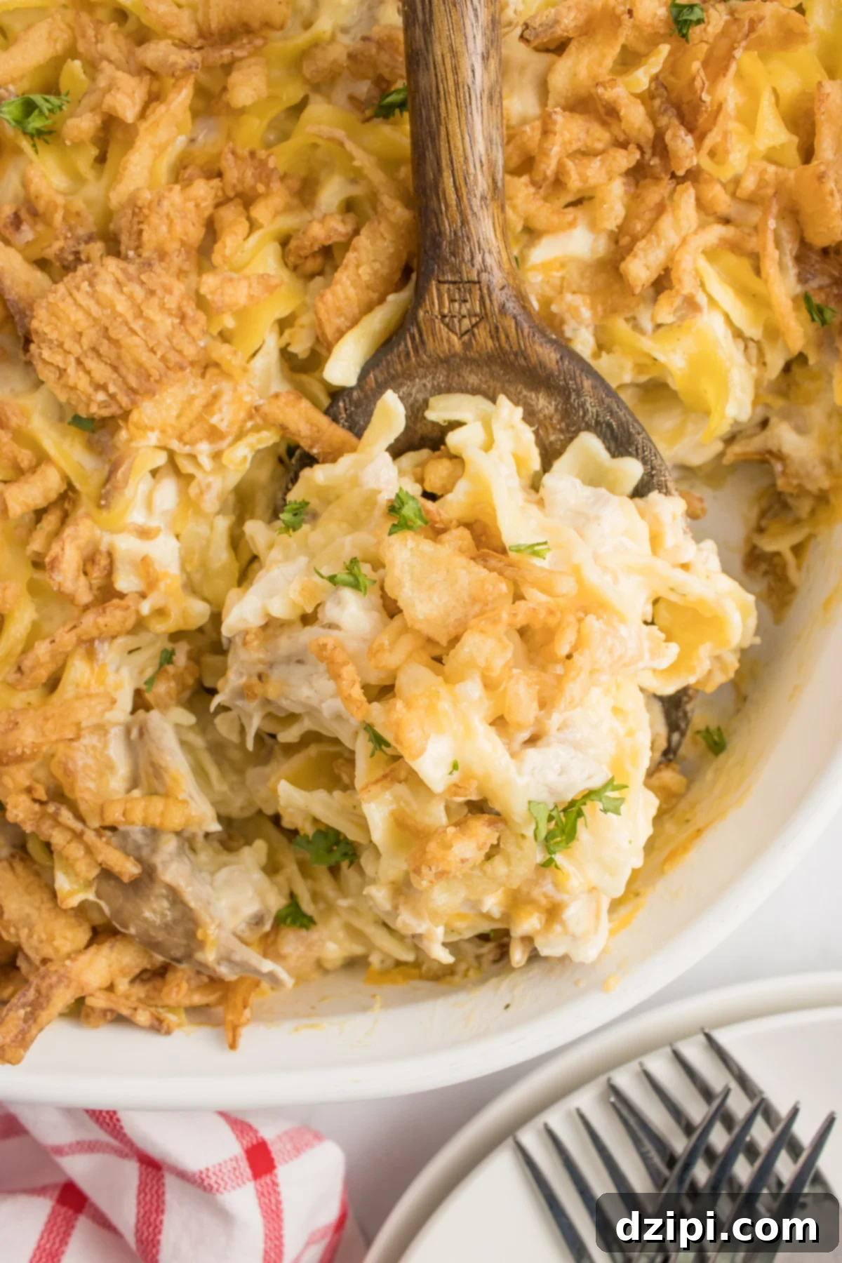 A wooden spoon with a scoop of French onion casserole.