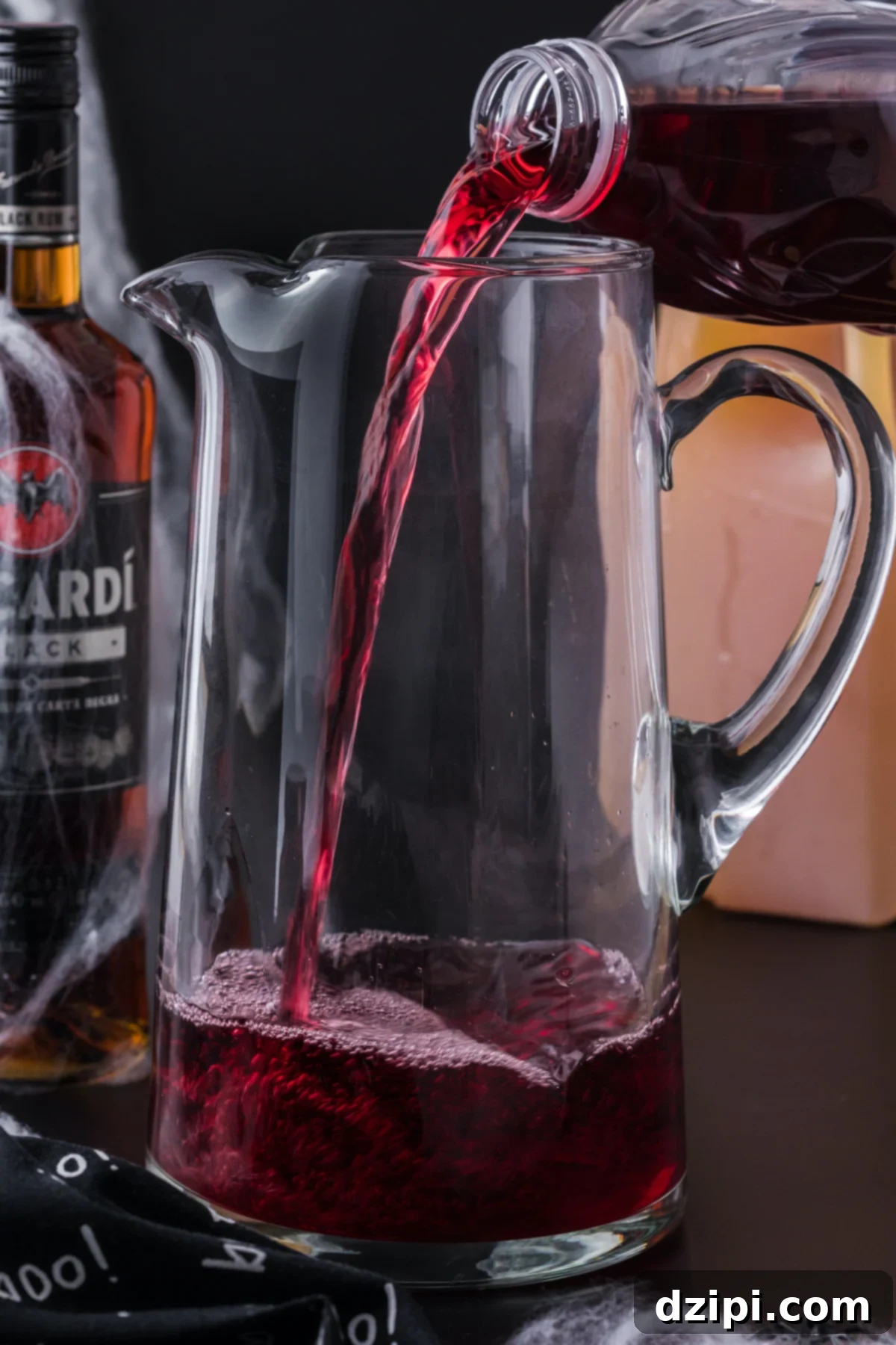 A tall glass pitched being filled with cran-grape juice.
