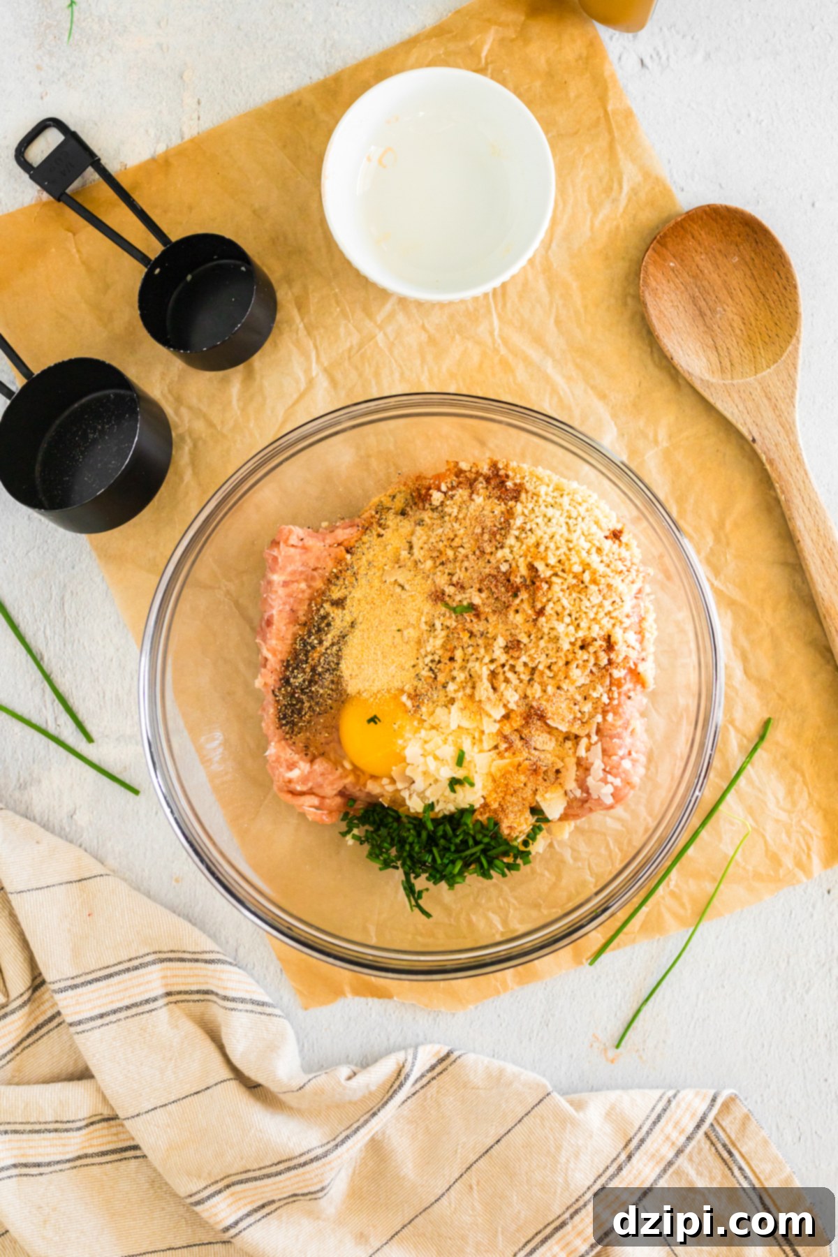 A mixing bowl is filled with all the ingredients to make firecracker meatballs.