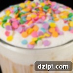 A vibrant birthday cake latte topped with thick cold foam and colorful confetti sprinkles, ready to be enjoyed as a festive treat.