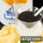 A tin of potato chips, a glass caviar chiller with ice on the bottom and caviar on top, and a plate of potato chips with a jar of creme fraiche topped with sliced green onions.