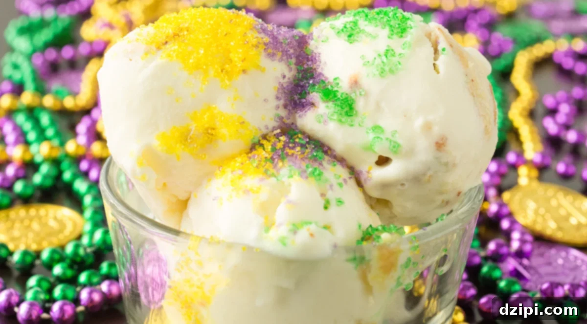 Three scoops of King Cake ice cream in a glass bowl that's surrounded by Mardi Gras beads. This scoops are topped with yellow, purple, and green sanding sugar.