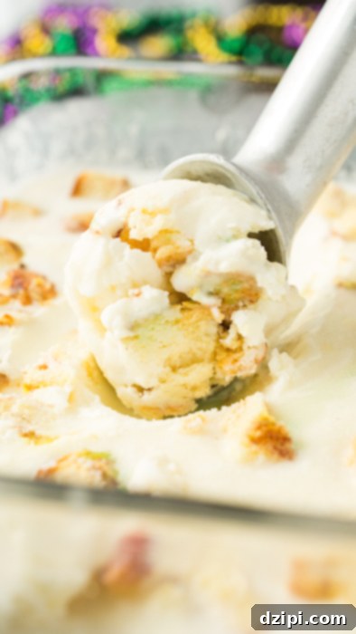 Homemade king cake ice cream being scooped out of a shallow glass pan