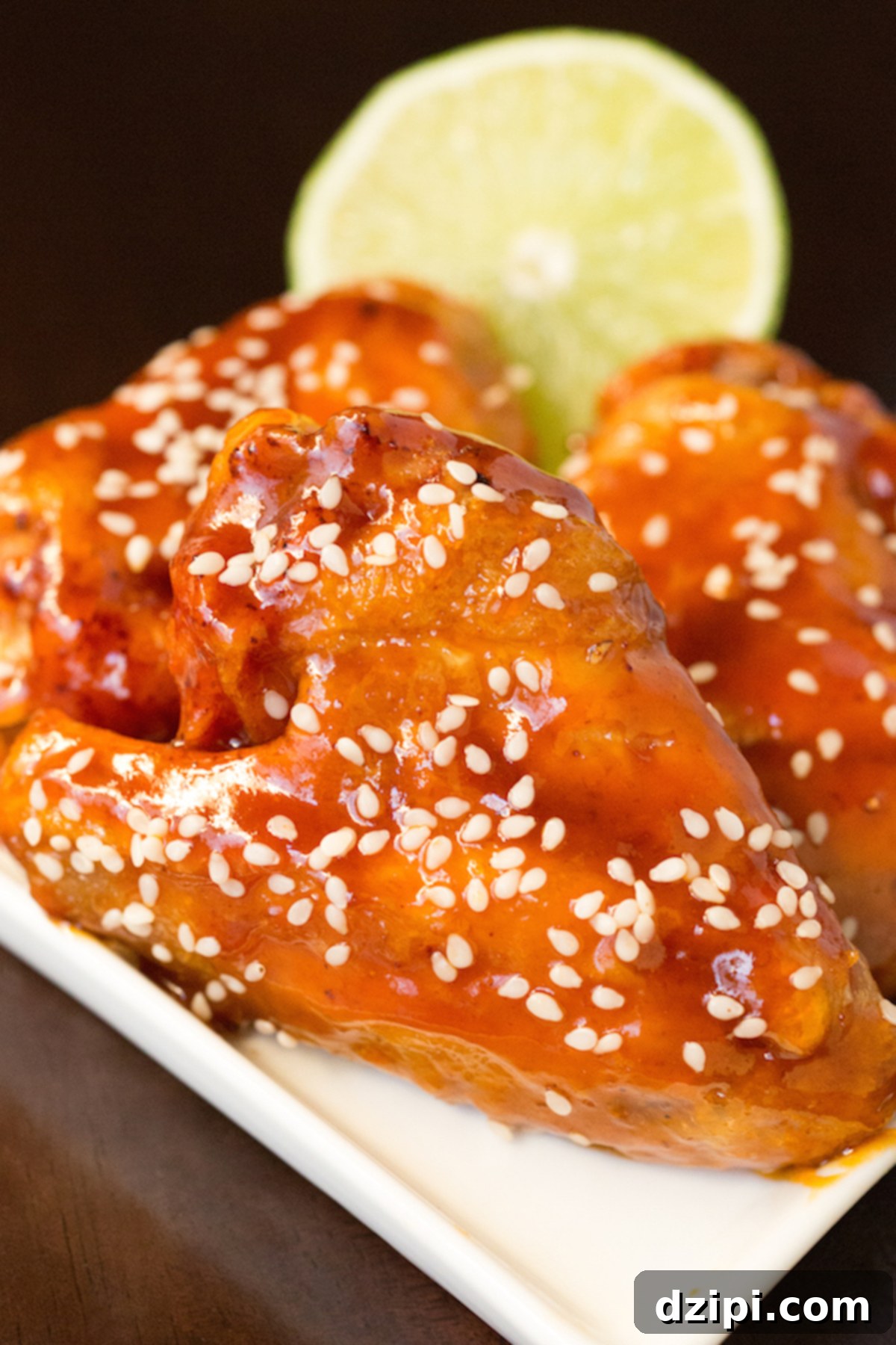 Sticky Honey Sriracha Wings 3 A close up of the sriracha honey lime wings with a half lime in the back.